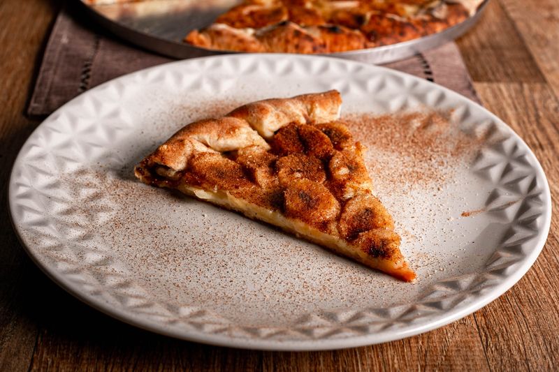 Jet's pizza team proudly displaying fresh pizzas